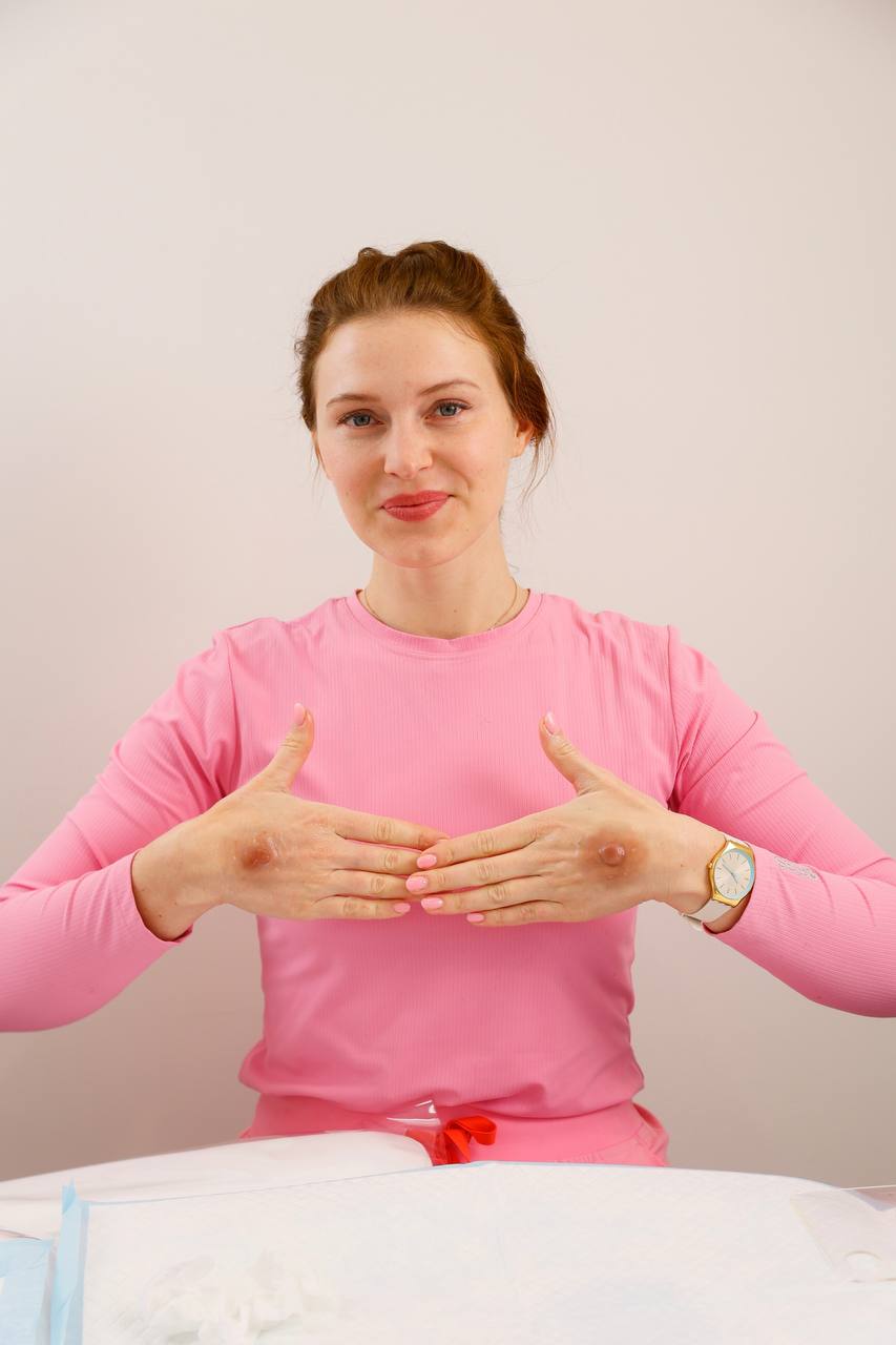 Dasha in pink demonstrating an areola tattoo, Breast Cancer Foundation NZ partner